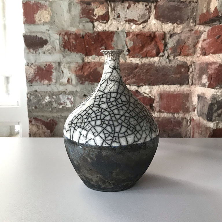 Color photo of a raku vase with matte dark blue crackle glaze on the bottom and clear crackle glaze on top by megan f. hopkins eurus ceramics handmade wheelthrown